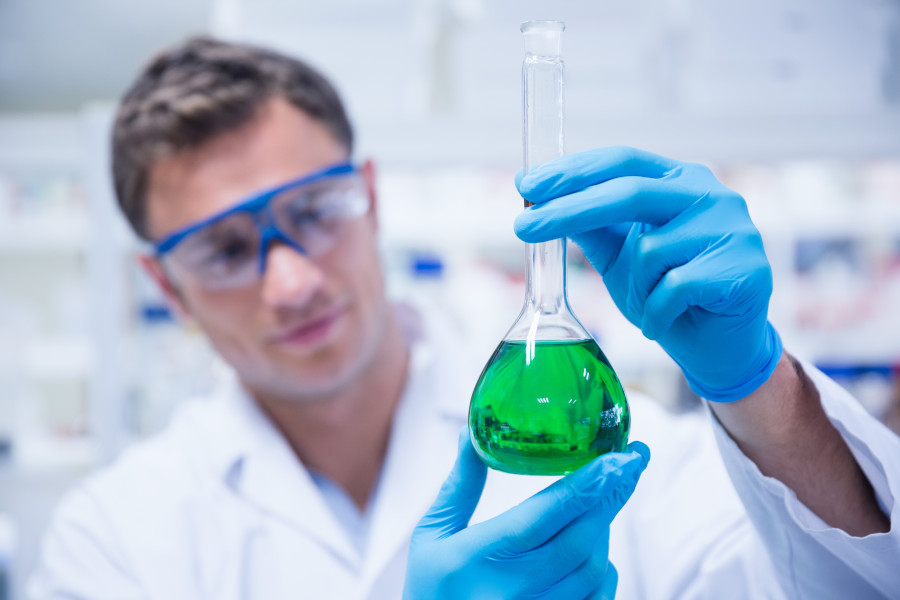 Chemist inspecting a zinc phosphate solution in the Labtech lab